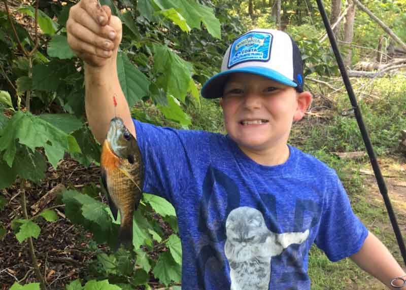 kid holds up a bluegill