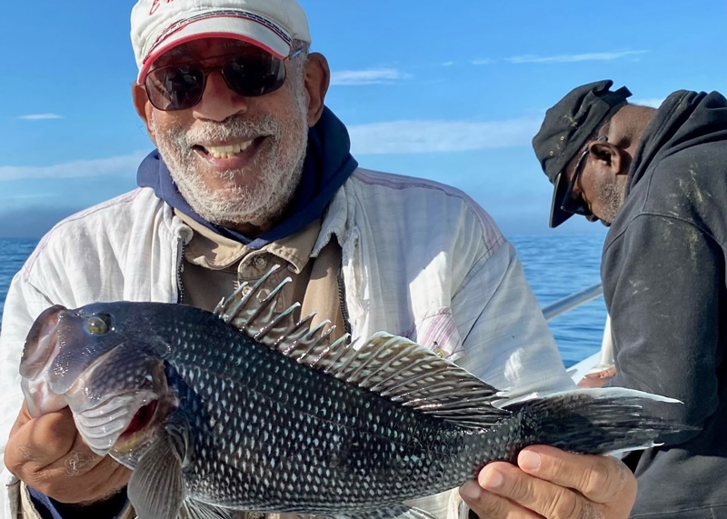 head boat angler with sea bass