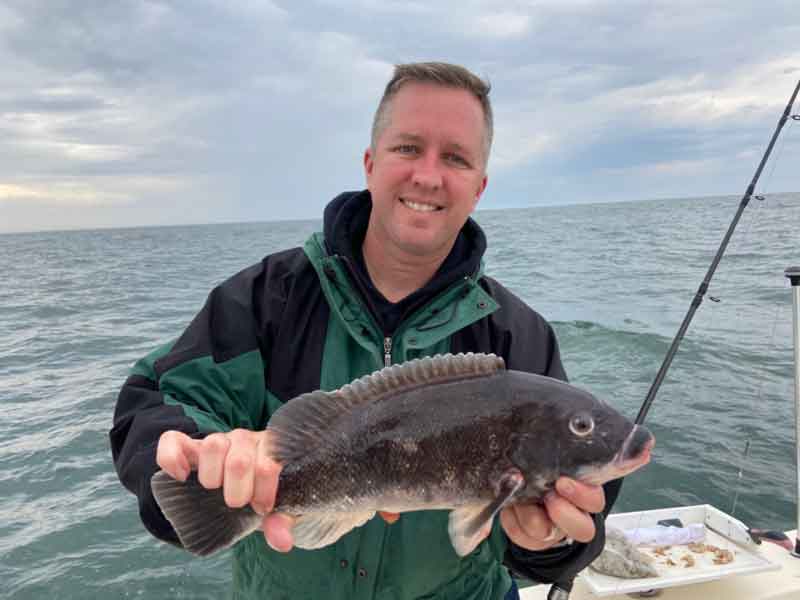tautog angler holds up his catch