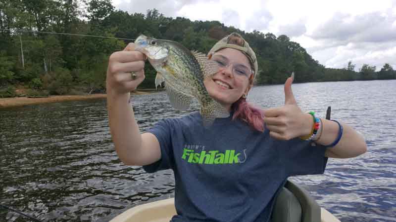 angler holds up a crappie fish she caught