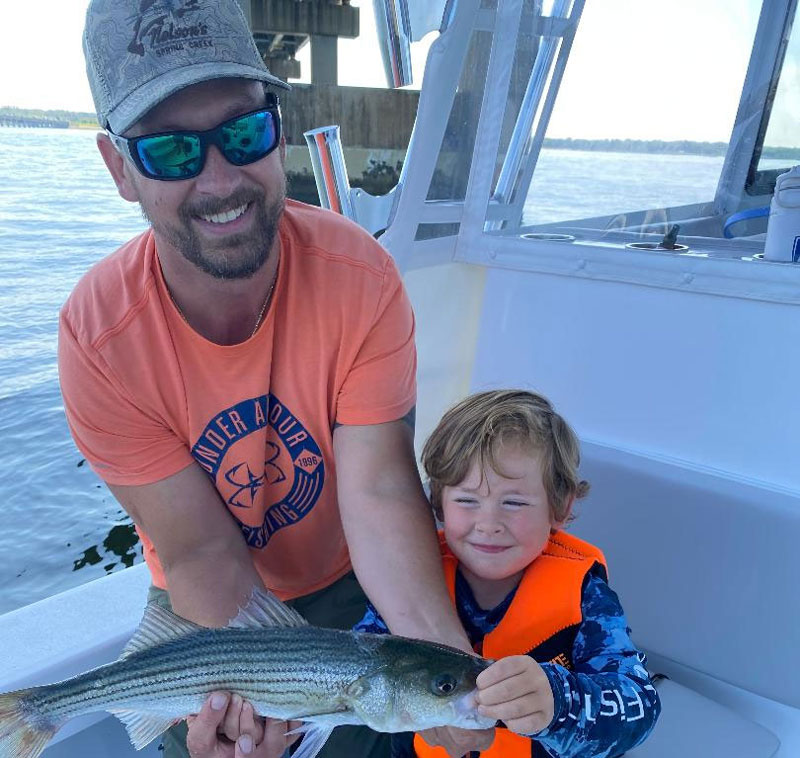 a dad and his son fishing on a pilothouse boat