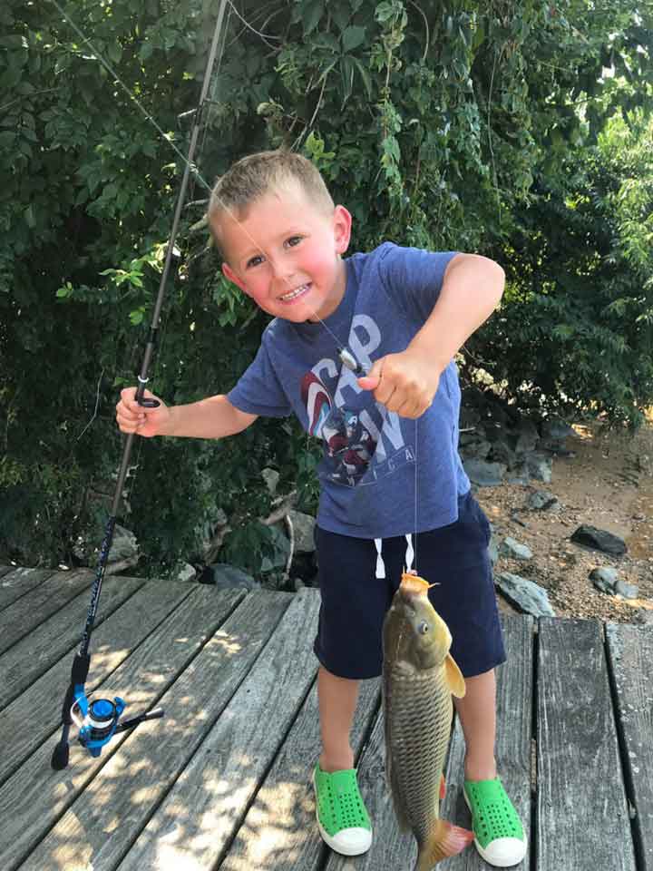 a boy catches his first carp