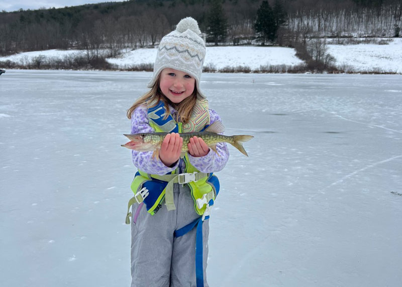 girl ice fishing caght a pickerel