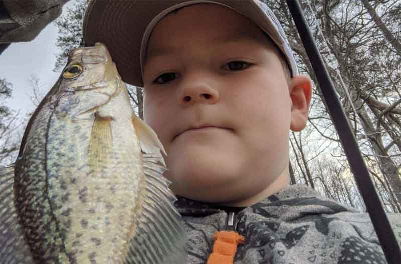kid holding up a crappie
