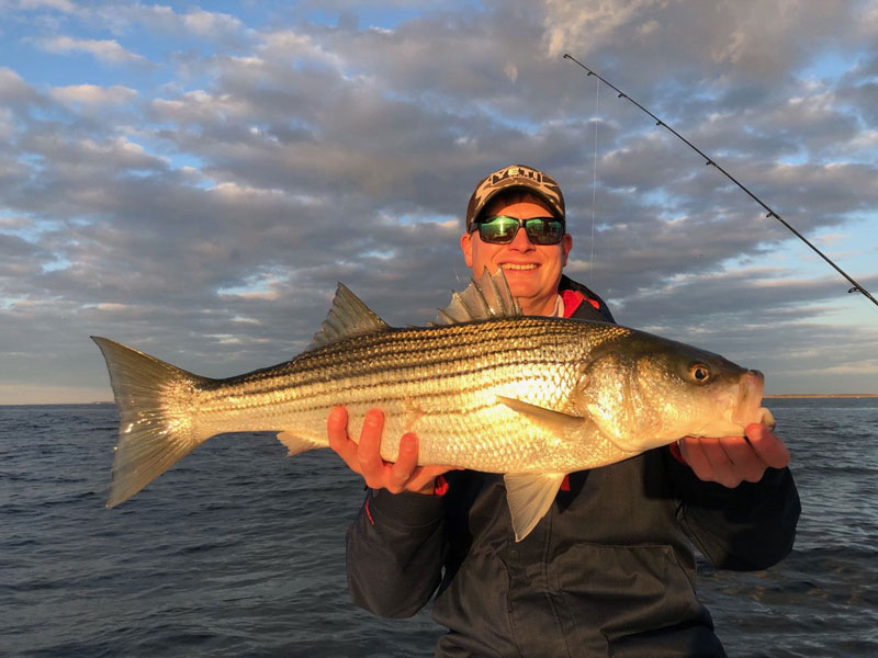 a lower bay striper held up by kevin