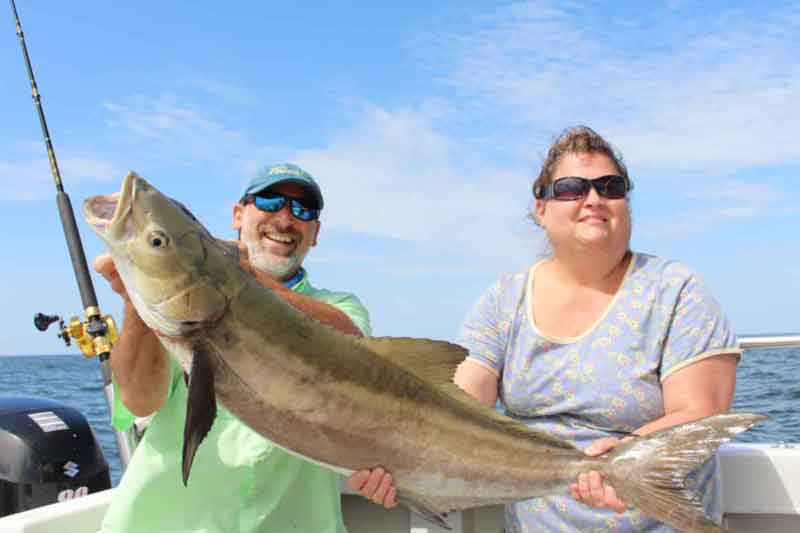 happy anglers with a cobia