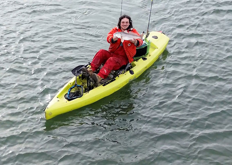 kayak angler catching slot redfish in chesapeake bay