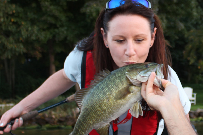 angler kissing a smallmouth bass