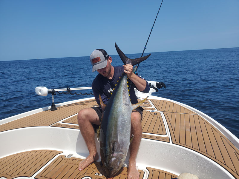 angler with a tuna on the caymas 26 hb center console