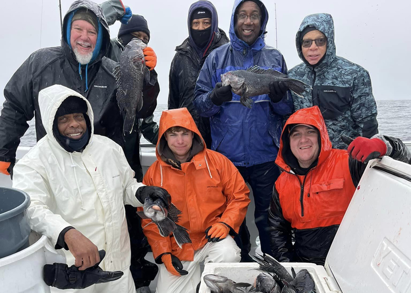 anglers on big worm with sea bass